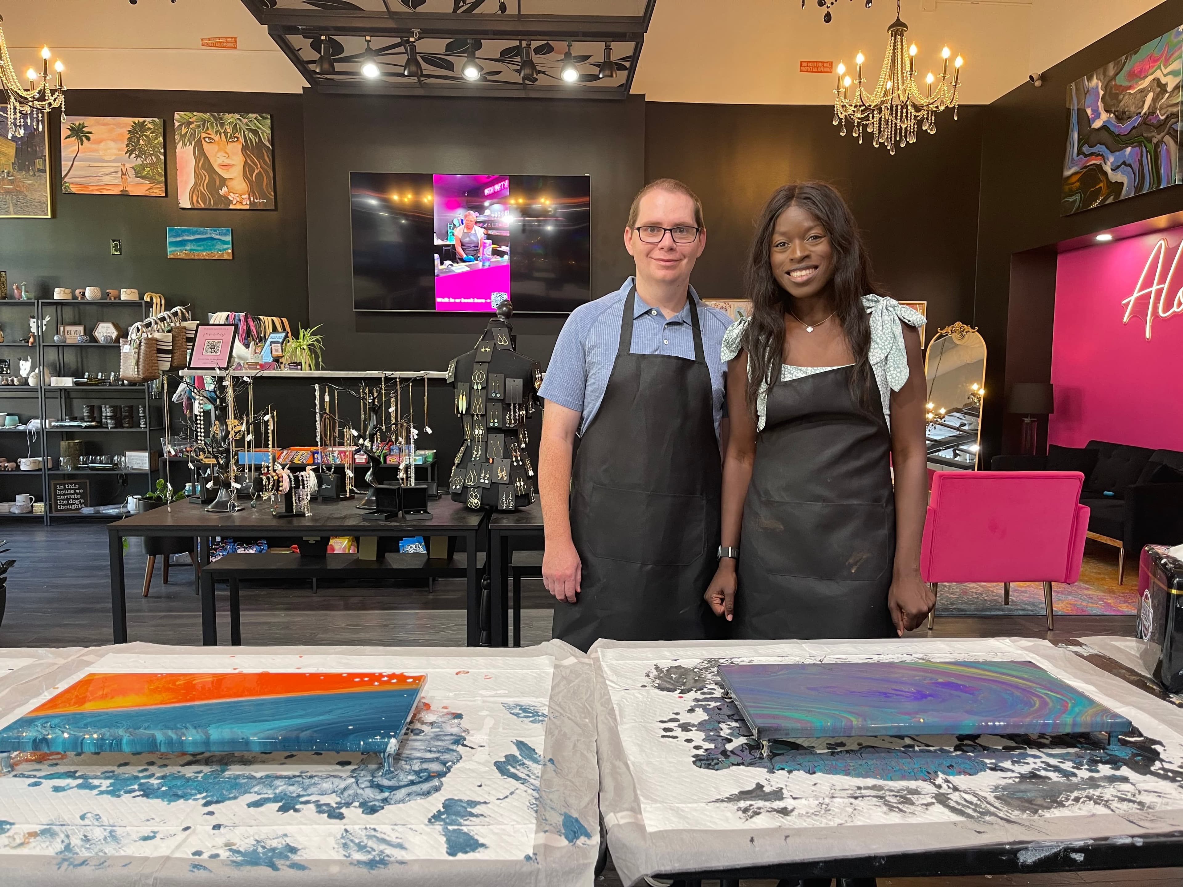 A couple celebrating their finished fluid art canvases on date night at ATL Fluid Art