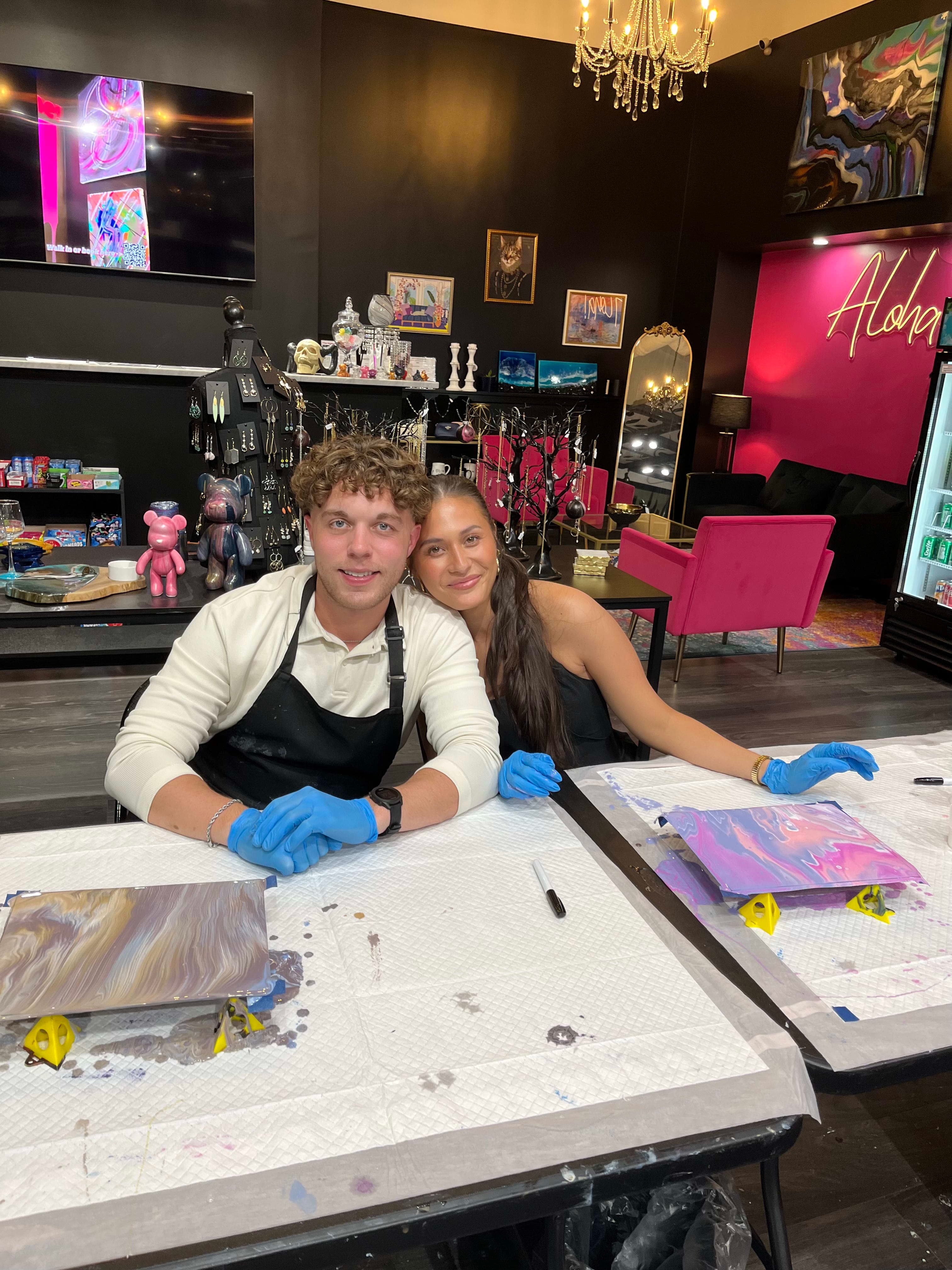 A couple admiring their finished glass painting on date night at ATL Fluid Art